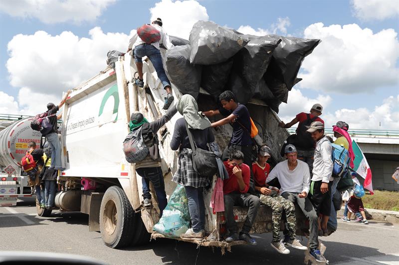 Migrantes hondure&ntilde;os suben a veh&iacute;culos que se encuentran en el camino para continuar otro tramo del territorio mexicano rumbo a su objetivo principal, Estados Unidos,