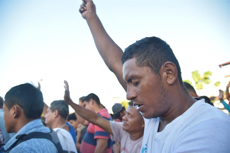 Migrantes hodure&ntilde;os realizan un minuto de silencio en memoria de del migrante que cay&oacute; de un transporte el d&iacute;a de ayer cuando se movilizaban hacia la poblaci&oacute;n de Huixtla, en el estado de Chiapas (M&eacute;xico), durante su traves&iacute;a hacia Estados Unidos hoy, martes 23 de octubre de 2018.