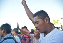 Migrantes hodureños realizan un minuto de silencio en memoria de del migrante que cayó de un transporte el día de ayer cuando se movilizaban hacia la población de Huixtla, en el estado de Chiapas (México), durante su travesía hacia Estados Unidos hoy, martes 23 de octubre de 2018.