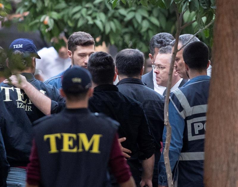 Miembros de la policía escoltan al religioso estadounidense Andrew Brunson (3-d), mientras trata de entrar a su domicilio tras su salida de un juicio en Izmir