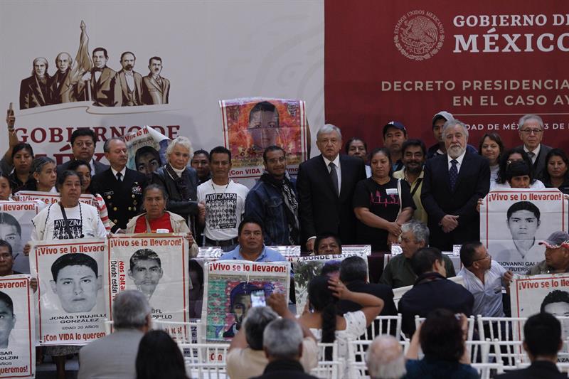 El presidente de M&eacute;xico Andr&eacute;s Manuel L&oacute;pez Obrador (c) posa con familiares de los 43 normalistas desaparecidos en Ayotzinapa durante la firma del decreto presidencial para la instalaci&oacute;n de una Comisi&oacute;n de la Verdad hoy, lunes 3 de diciembre de 2018 en Ciudad de M&eacute;xico (M&eacute;xico).