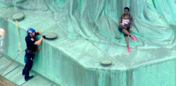 Mujer protestando en la Estatua de la Libertad