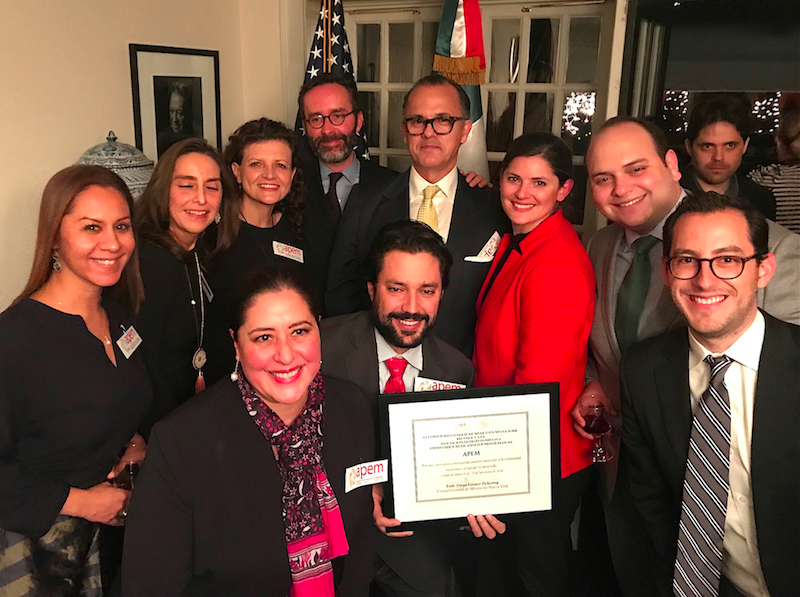 Al entregar el reconocimiento a APEM, el C&oacute;nsul G&oacute;mez expres&oacute;: Este es un reconocimiento por estos cinco a&ntilde;os construyendo puentes para unificar a la comunidad mexicana, para fomentar su desarrollo futuro. Gracias por su trabajo y sus servicios. Aqu&iacute; pos&oacute; junto a algunos miembros de APEM.