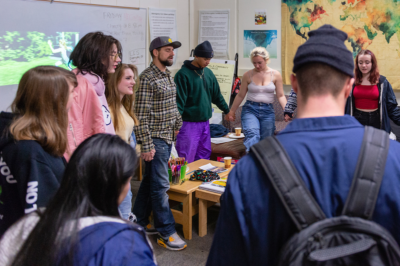 Estudiantes se toman las manos en círculo antes que termine el día escolar. Los estudiantes se reúnen a diario con consejeros y participan de programas de apoyo diseñados como Alcohólicos Anónimos. (Heidi de Marco/KHN)