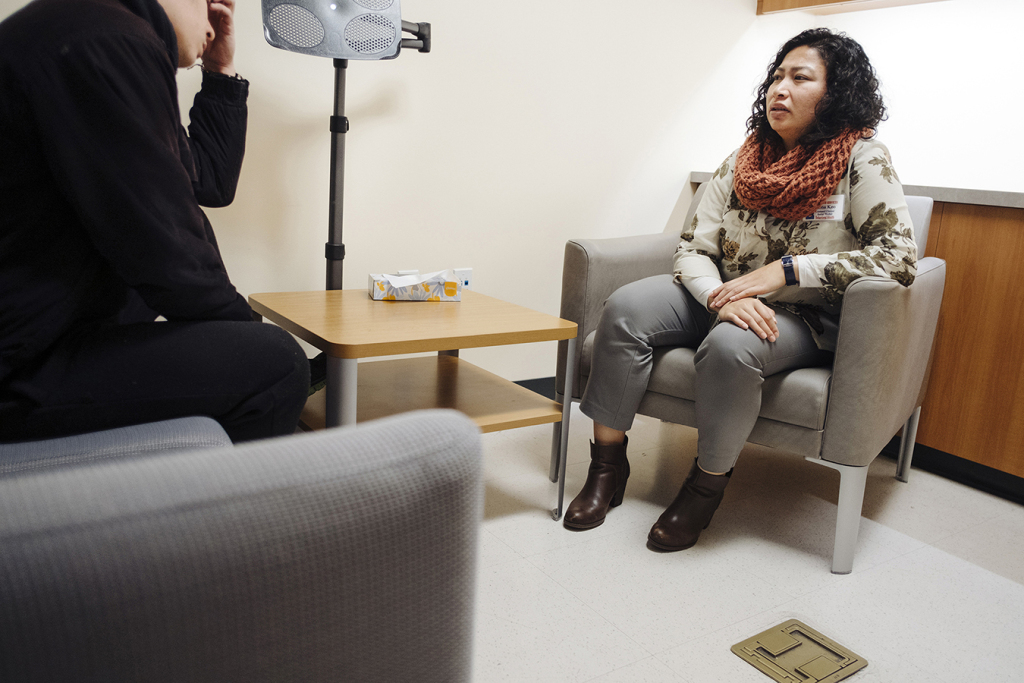 La consejera de salud mental Zona Keo habla con un cliente en una clínica dental de Asian Health Services en Oakland.