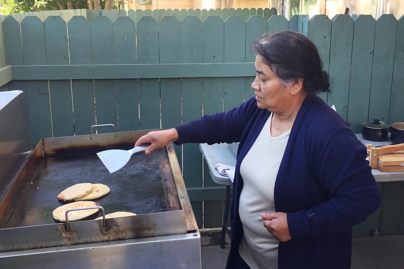 Mar&iacute;a Contreras prepara pupusas para el negocio de su familia de venta de comida. El objetivo es ayudar a reemplazar los ingresos de su hermano. (Sarah Varney / KHN)