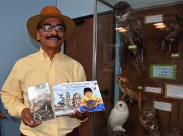 René Corado, mientras muestra su libro "El ilustrador" y su versión infantil "Las aventuras de René Corado, el lustrador".