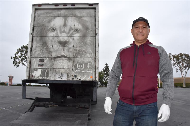 El mexicano Arnulfo Gonz&aacute;lez posa frente a la figura de un le&oacute;n que dibuj&oacute; en la puerta trasera de su cami&oacute;n
