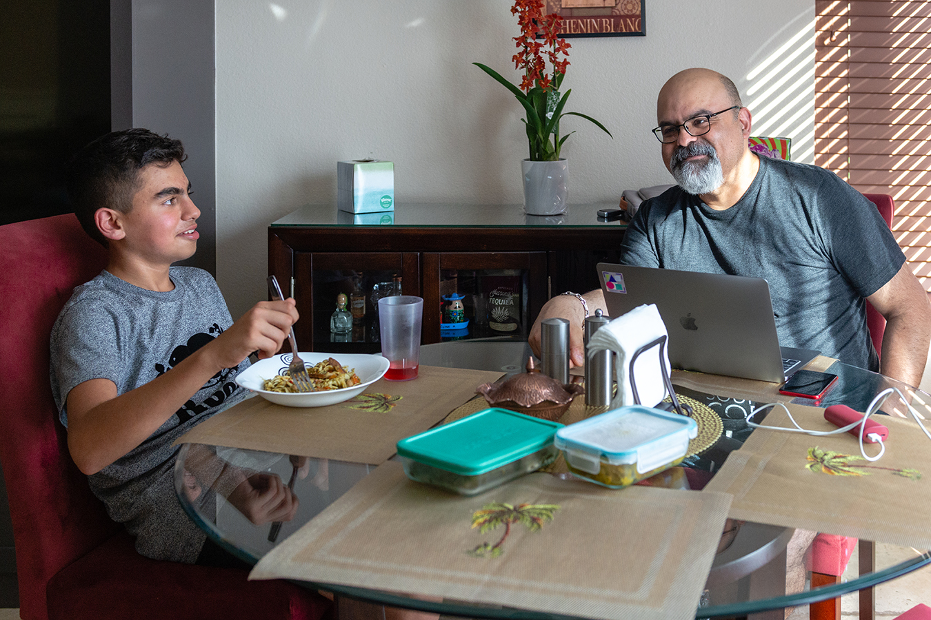 Sam y su pap&aacute;, Ali, almorzando en su casa de Irvine, California. (Heidi de Marco/KHN)