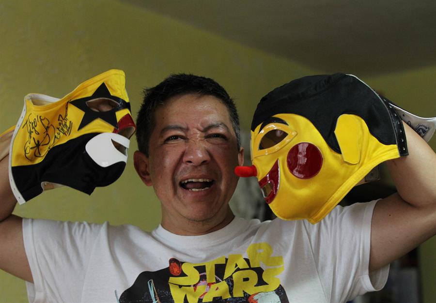 El fabricante de m&aacute;scaras de luchador, Pedro Rosas Kenjiro, posa con dos m&aacute;scaras.