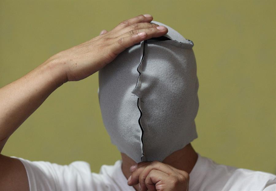 El fabricante de m&aacute;scaras de luchador, Pedro Rosas Kenjiro, se prueba una m&aacute;scara al rev&eacute;s en la que est&aacute; trabajando.