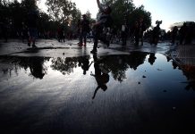 Fuerzas Especiales de Carabineros dispersan una concentración convocada en la céntrica Plaza Italia, este miércoles durante la duodécima jornada de protestas a nivel nacional en contra del Gobierno, en Santiago (Chile).