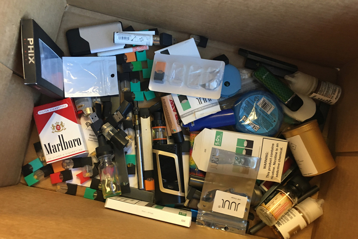 Kristen Lewis, subdirectora de Boulder High School, guarda una caja con productos de vapeo que estudiantes desecharon o que ella confiscó. Luego la entrega a las instalaciones de residuos peligrosos del condado. (John Daley/Colorado Public Radio)