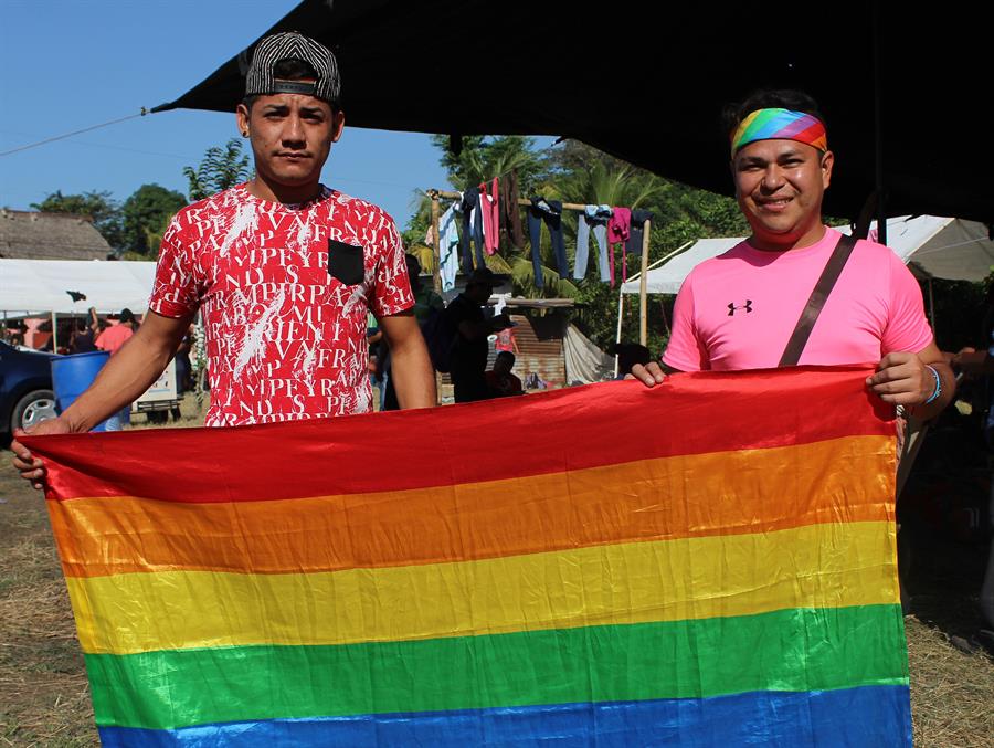  Los activista LGBT Jos&eacute; V&aacute;zquez (i) y Mavisa (d), quienes viajan en la caravana de migrantes hondure&ntilde;os, posan con la bandera de arco&iacute;ris.
