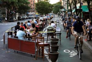 La gente cena afuera en la avenida Columbus en Nueva York.
