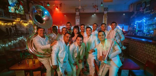 Mon Laferte (c) mientras posa con los integrantes de la Arrolladora Banda Limón