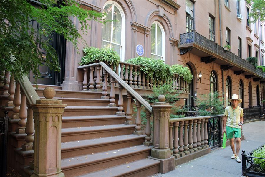 Un hombre camina frente a la fachada de una casa supuestamente embrujada donde vivió Emma Lazarus, la poeta creadora del poema que luce bajo la Estatua de la Libertad, el 20 de julio de 2022, en Nueva York (EE.UU.).