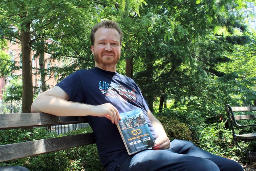 El periodista español Javier Pintado posa con su libro "100 lugares misteriosos de Nueva York", durante una entrevista con Efe, el 20 de julio de 2022, en el parque de Washington Square, en el sur de Manhattan, Nueva York (EE.UU.).