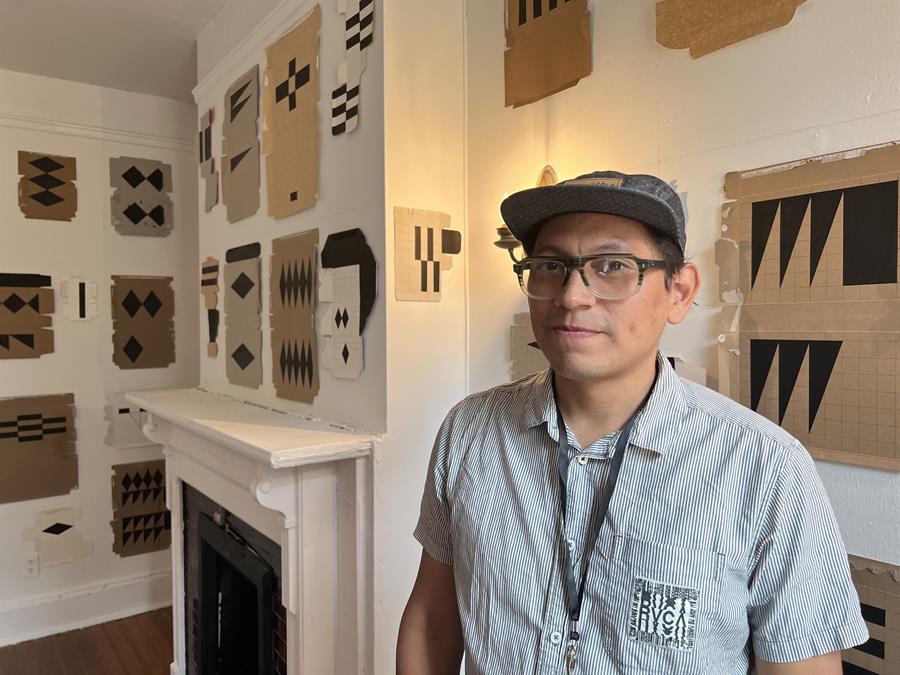 El artista paname&ntilde;o Apanalexander Wtges posa junto a varias de sus obras