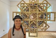 La artista ecuatoriana Carmen Vicente posa junto a su obra La Chakana Florida