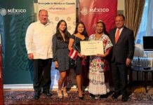 La maestra Beatriz Ceballos Poot (2d) sostiene un reconocimiento junto al cónsul de México en Ottawa