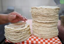 Organización mexicana dice que precio de tortilla no bajará en próximos meses una mujer mientras prepara tortillas