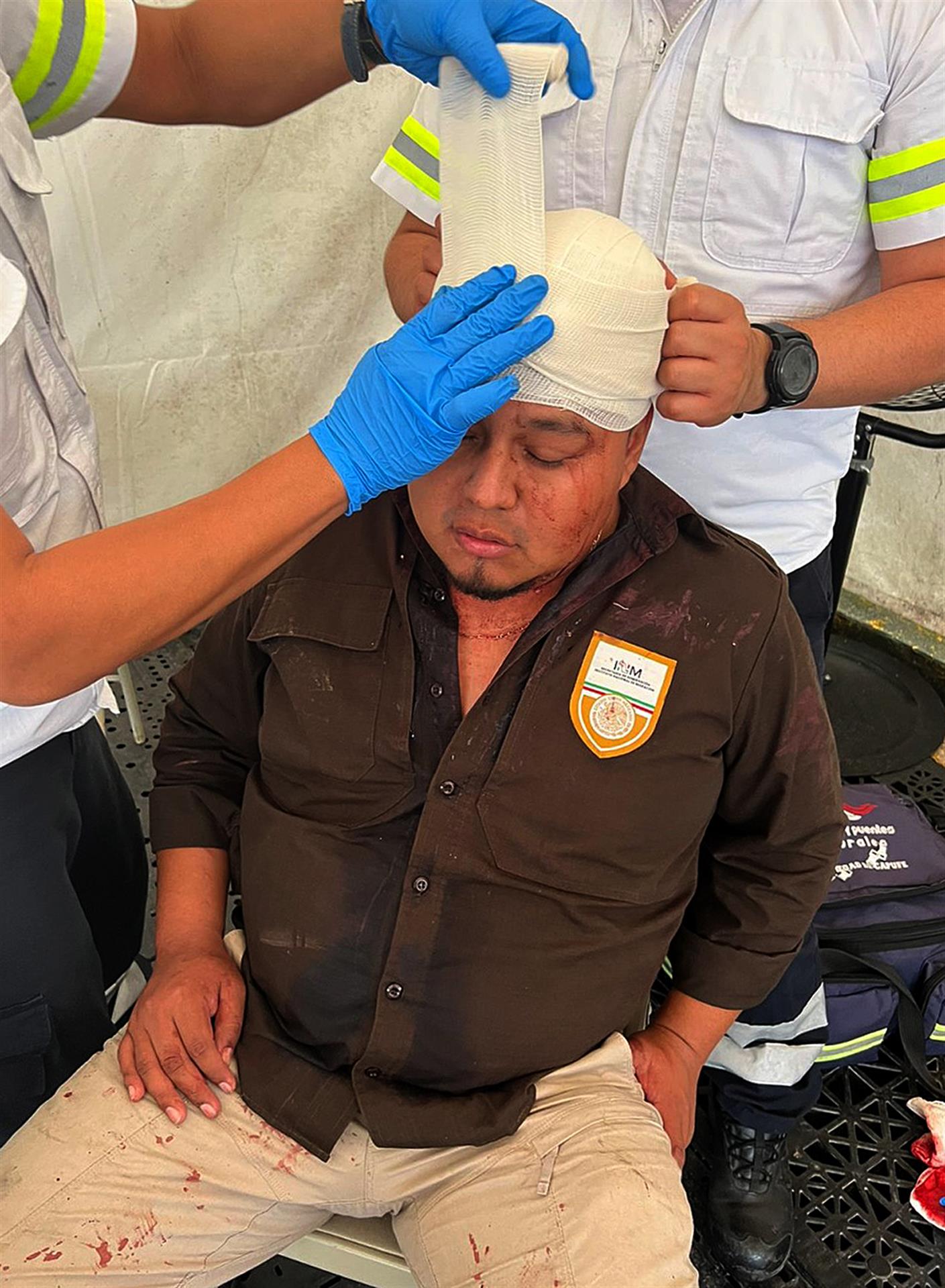 Un integrante del Instituto Nacional de Migraci&oacute;n (INM) recibe atenci&oacute;n m&eacute;dica hoy, luego der ser agredido por migrantes