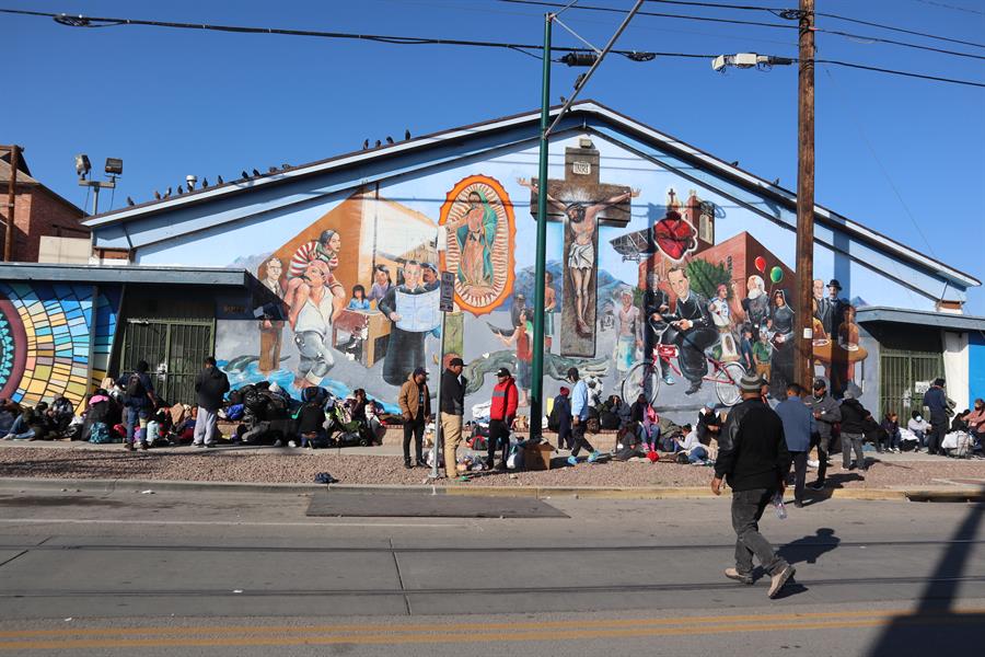 Inmigrantes descansan en el piso en los exteriores de un albergue, en El Paso