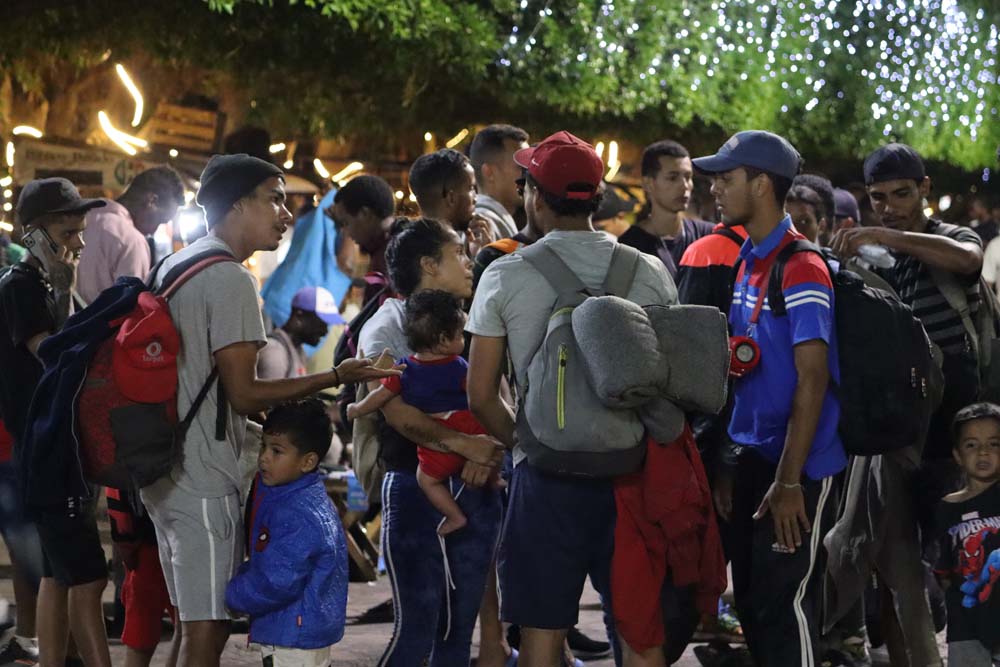 Migrantes esperan a lo largo del río Bravo después de que las fuerzas del orden estadounidenses instalaran una barricada a lo largo del río para evitar que los migrantes crucen ilegalmente a Estados Unidos desde México en Ciudad Juárez, México