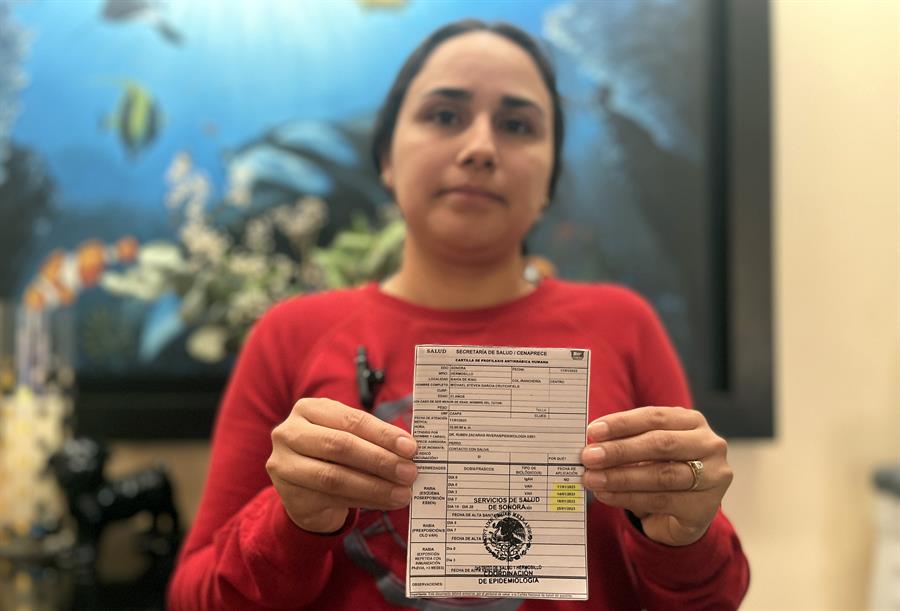  La se&ntilde;ora Y&eacute;sica Guadalupe Pacheco, muestra un carnet de vacunaci&oacute;n antirr&aacute;bica de un integrante de su familia