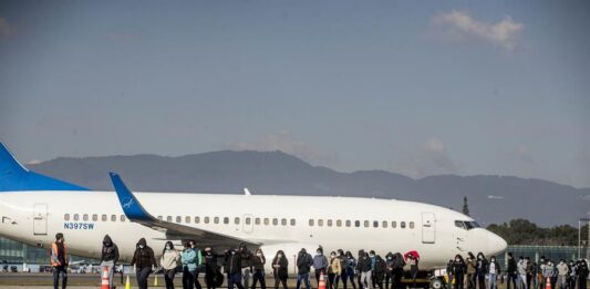 Un grupo de personas deportadas caminan hoy, provenientes del primer vuelo desde los Estados Unidos a Guatemala
