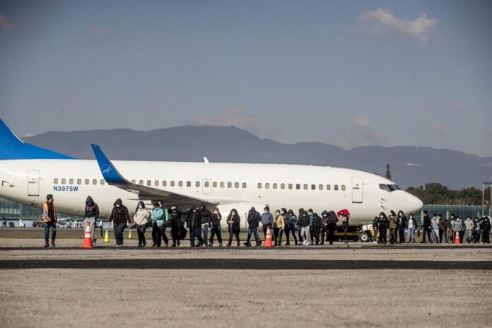 Un grupo de personas deportadas caminan hoy, provenientes del primer vuelo desde los Estados Unidos a Guatemala