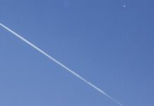Un avión comercial (i) vuela por debajo del globo espía chino