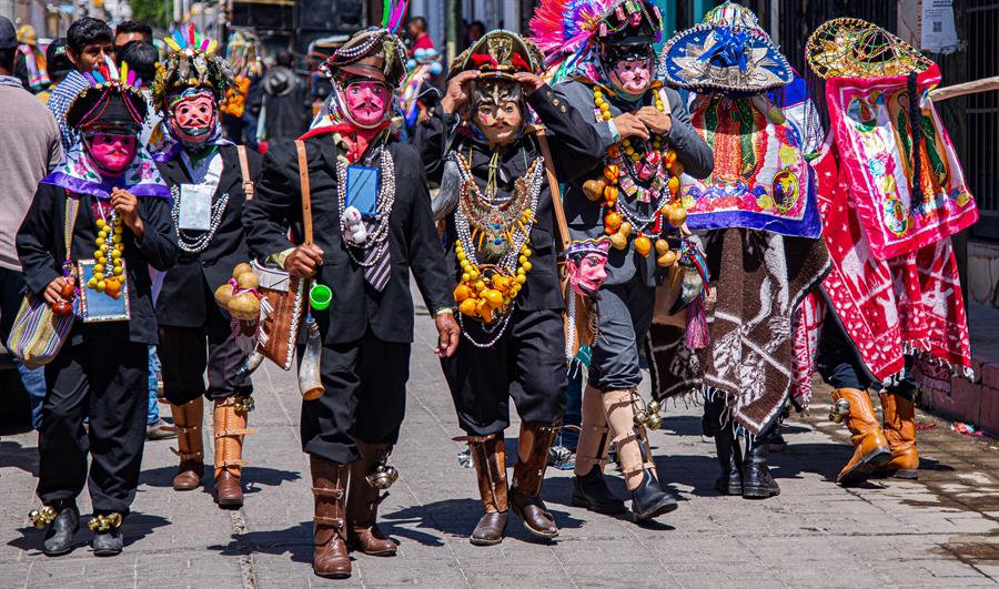 Un grupo de hombres ind&iacute;genas, bailan con coloridos trajes y mascaras (3)