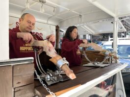 Las dos patronales del jamón español se unen para "vender felicidad" en EE.UU. Dos personas cortan hoy jamón ibérico en el camión de la felicidad (2)