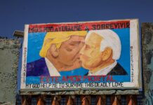 Vista de una pintura del expresidente estadounidense Donald Trump besando al actual mandatario, Joe Biden (2)