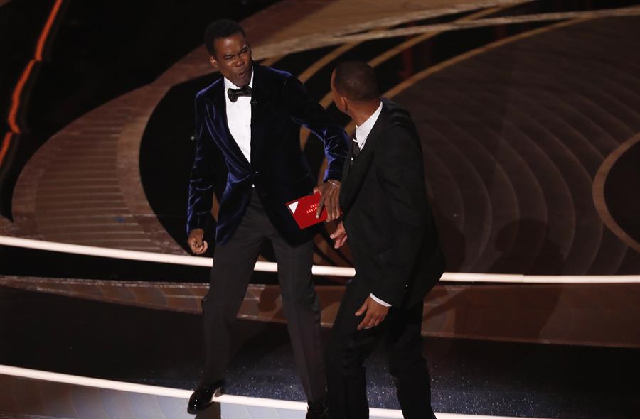 Will Smith (d) mientras abofetea al presentador de la gala Chris Rock