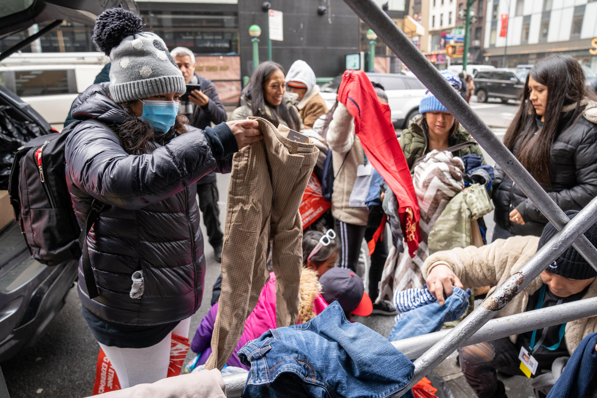 Migrantes reciben ropa donada, el 2 de marzo de 2023, frente al hotel donde residen en el barrio de Manhattan en Nueva York. 
