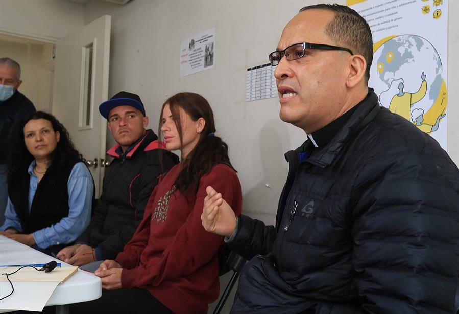 El padre Javier Calvillo (d) habla con migrantes venezolanos y activistas