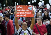 Un hombre sostiene un cartel durante una manifestación del sindicato de profesores,