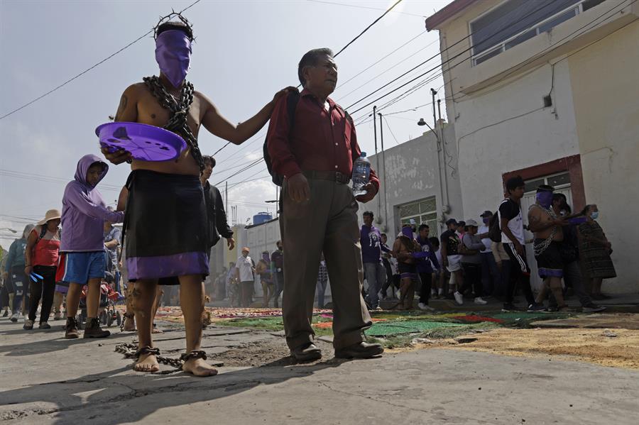 Una persona se prepara para participar en la procesión de los engrillados este Viernes Santo (2)