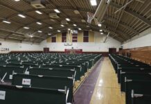 Algunos de los doscientos setenta y cinco catres de la Cruz Roja para atención de migrantes, dispuestos en hileras en la cancha de baloncesto cubierta de la escuela secundaria Basset, en El Paso, Texas.