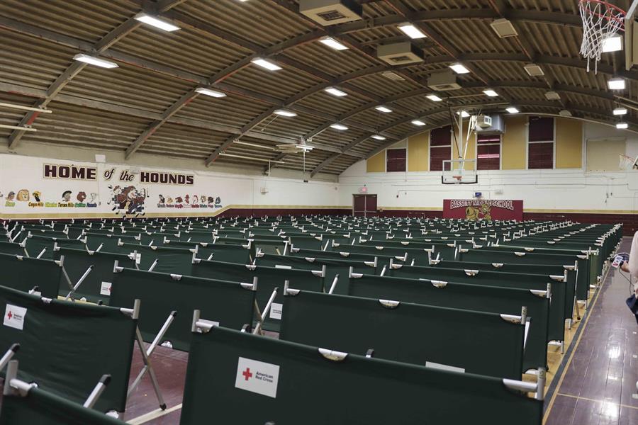 Algunos de los doscientos setenta y cinco catres de la Cruz Roja para atenci&oacute;n de migrantes, dispuestos en hileras en la cancha de baloncesto cubierta de la escuela secundaria Basset, en El Paso, Texas.