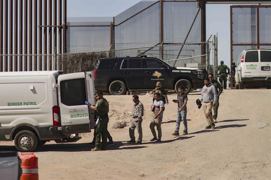 Migrantes detenidos son llevados hoy por miembros de la Patrulla Fronteriza estadounidense a un vehículo (2)