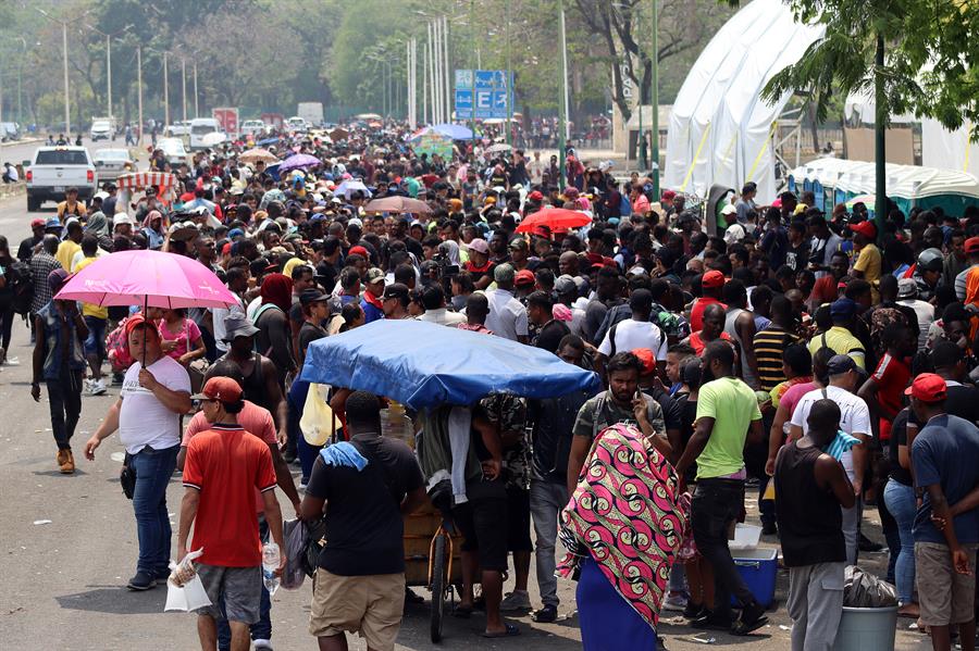 Migrantes hacen fila para tramitar papeles migratorios Migrantes