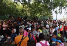 Cientos de migrantes esperan bajo el sol, frente a las puertas de la valla fronteriza que separa México de Estados Unidos, a que las autoridades los deporten o los procesen, a dos días de que expire el Título 42, la norma que permite expulsiones en caliente por motivos de salud pública.