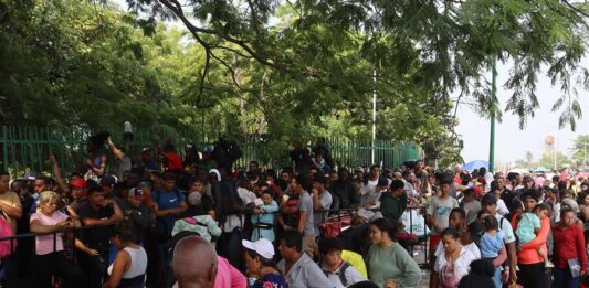 Cientos de migrantes esperan bajo el sol, frente a las puertas de la valla fronteriza que separa México de Estados Unidos, a que las autoridades los deporten o los procesen, a dos días de que expire el Título 42, la norma que permite expulsiones en caliente por motivos de salud pública.
