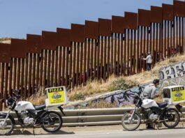 Repartidores de comida rápida entregan pedidos a migrantes en el muro fronterizo (1)