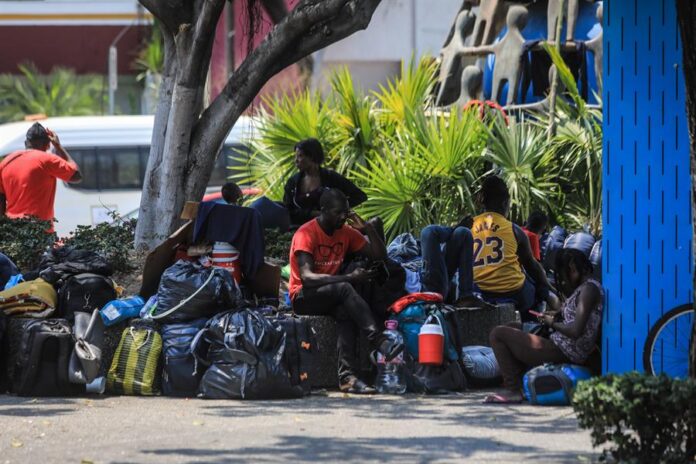 Un grupo de migrantes haitianos descansan cerca de las oficinas de Migración (2)