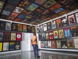 Un hombre mira una exposición de carteles permanentes en el Instituto Cubano del Arte e Industria Cinematográficos